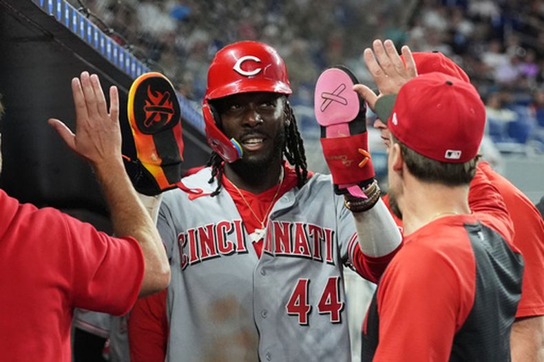 El dominicano Elly de la Cruz de los Rojos de Cincinnati felicitado por sus compañeros tras anotar en el sencillo de Sal Stewart en la cuarta entrada ante los Marlins de Miami el lunes 6 de abril del 2026. (AP Foto/Lynne Sladky)