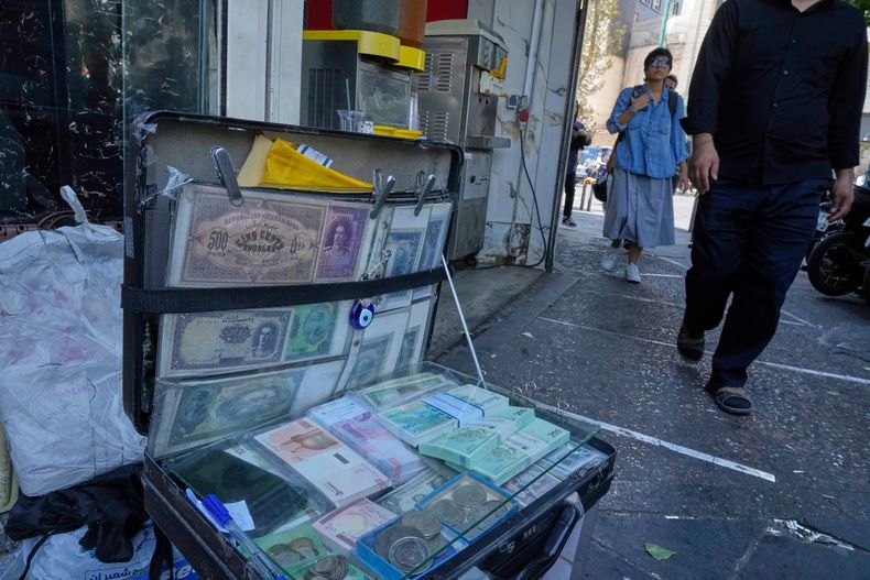 ARCHIVO — Billetes actuales iraníes y la etapa previa a la Revolución, en el puesto de un cambista callejero en la plaza Ferdowsi, en el centro de Teherán, Irán, el 28 de agosto de 2025. (AP Foto/Vahid Salemi, archivo)