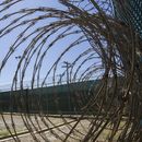 ARCHIVO - En esta fotografía del 17 de abril de 2019 revisada por oficiales militares de Estados Unidos se muestra una torre de control a través de alambre de púas dentro de un centro de detención en la base naval de la Bahía de Guantánamo, en Cuba. (AP Foto/Alex Brandon, Archivo)