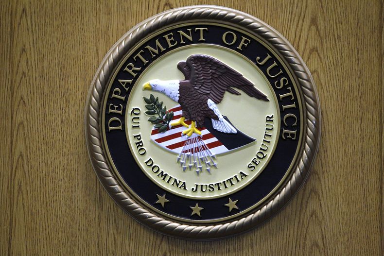 ARCHIVO - El logo del Departamento de Justicia es exhibido en un podio durante una conferencia de prensa, el 30 de septiembre de 2010, en Filadelfia. (AP Foto/Matt Slocum, archivo)