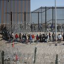 Migrantes formados después de ser detenidos por las autoridades migratorias de Estados Unidos en el muro fronterizo, el miércoles 27 de diciembre de 2023, en una imagen captada desde Ciudad Juárez, México. (AP Foto/Christian Chavez)