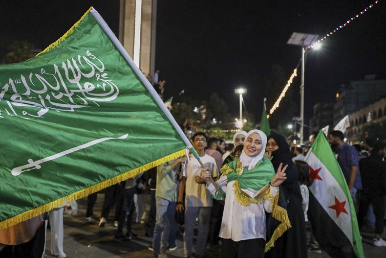 Una niña ondea una bandera de Arabia Saudí durante la celebración del anuncio de los planes del presidente de Estados Unidos, Donald Trump, durante una visita a Arabia Saudí, de aliviar las sanciones a Siria y normalizar las relaciones con su nuevo gobierno, en Homs, Siria, el 13 de mayo de 2025. (AP Foto/Omar Albam)