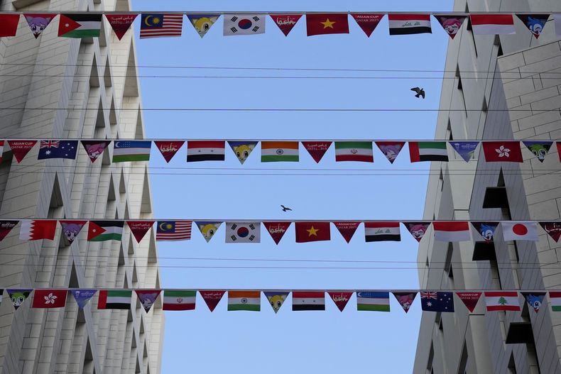 Las banderas de los países participantes se despliegan entre dos inmuebles, de cara a la Copa Asiática en Doha, Qatar, el miércoles 10 de enero de 2024 (AP FotoAijaz Rahi)