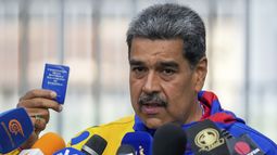 El presidente Nicolás Maduro muestra una mini edición de la Constitución venezolana después de votar en Caracas el domingo 28 de julio de 2024. (AP Foto/Fernando Vergara)