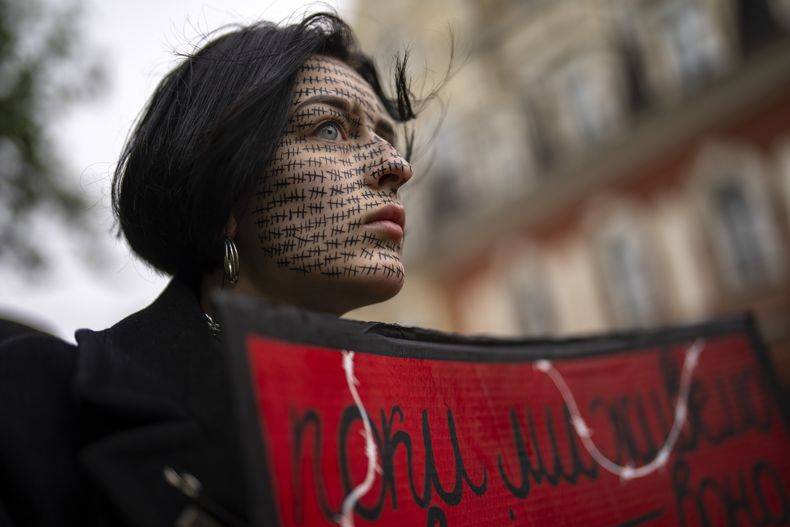 Una mujer sostiene un cartel de Azov libre durante una manifestación destinada a crear conciencia sobre el destino de los prisioneros de guerra ucranianos en Kiev, Ucrania, el domingo 21 de abril de 2024. (Foto AP/Francisco Seco)