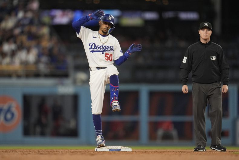 Mookie Betts, de los Dodgers de Los Ángeles, festeja luego de batear un doble remolcador ante los Nacionales de Washington, el martes 16 de abril de 2024 (AP Foto/Marcio José Sánchez)