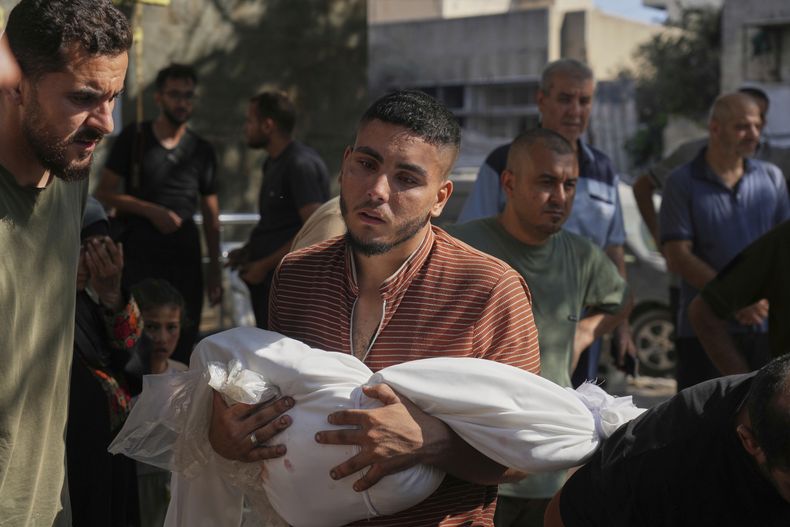 Un hombre lleva en brazos el cuerpo de un niño asesinado en un ataque israelí, ante el hospital de Shifa, en Ciudad de Gaza, el lunes 30 de junio de 2025. (AP Foto/Jehad Alshrafi)