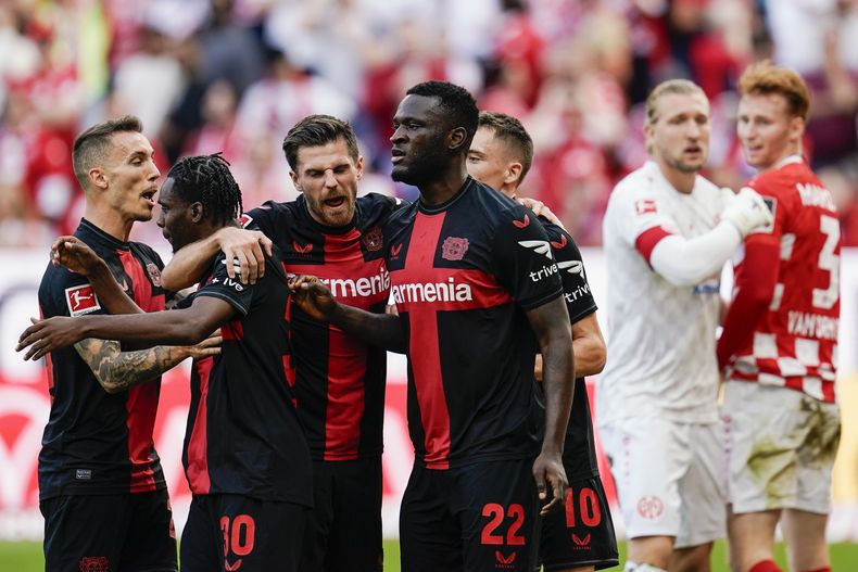 Jeremie Frimpong, Victor Boniface y otros jugadores del Bayer Levekrusen celebran después del autogol de Sepp van den Berg del Mainz en el encuentro de la Bundesliga del sábado 30 de septiembre del 2023. (Uwe Anspach/dpa via AP)