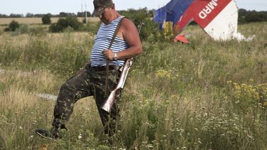 americateve | Un combatiente pro ruso camina frente a uno de los restos del derribado avi&oacute;n de Malaysia Airlines cerca del poblado de Hrabove, UCrania, el lunes 21 de julio de 2014. (Foto AP/Dmitry Lovetsky)