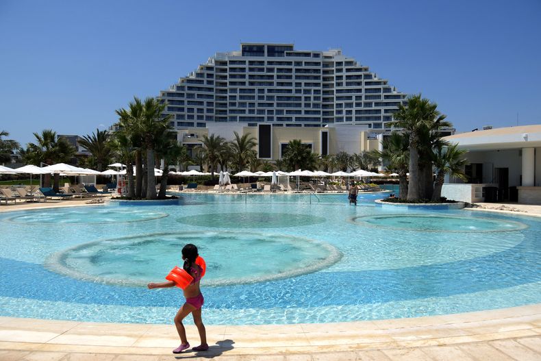 Un niño disfruta de la piscina en el City of Dreams Mediterranean, el martes 11 de julio de 2023, en la ciudad de Limassol, Chipre. (AP Foto/Petros Karadjias)