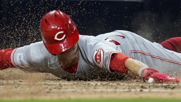 TJ Friedl, de los Rojos de Cincinnati, se desliza para anotar en el octavo inning del juego ante los Padres de San Diego, el martes 2 de mayo de 2023 (AP Foto/Gregory Bull)