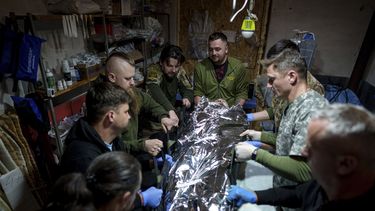 Médicos militares ucranianos colocan a un camarada herido en una camilla en un hospital de campaña en dirección a Avdiivka, en la región de Donetsk, Ucrania, el viernes 10 de mayo de 2024. (AP Foto/Evgeniy Maloletka)