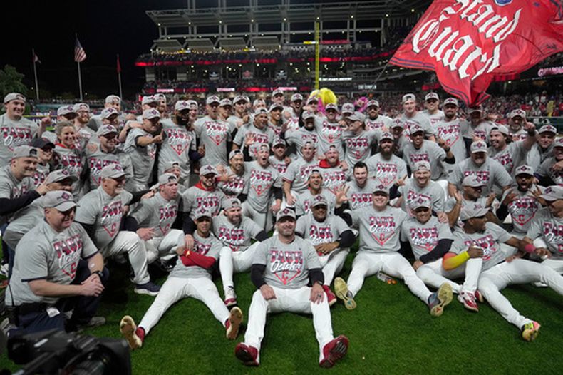 Los jugadores y coaches de los Guardianes de Cleveland celebran su victoria ante los Medias Blancas de Chicago en la serie divisional de la Liga Americana, el sábado 10 de octubre de 2026, en Cleveland. (AP Foto/Sue Ogrocki)