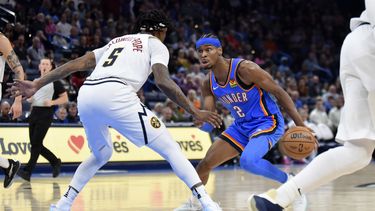 Shai Gilgeous-Alexander, base del Thunder de Oklahoma, busca avanzar frente a Kentavious Caldwell-Pope, de los Nuggets de Denver, el miércoles 31 de enero de 2024 (AP Foto/Kyle Phillips)
