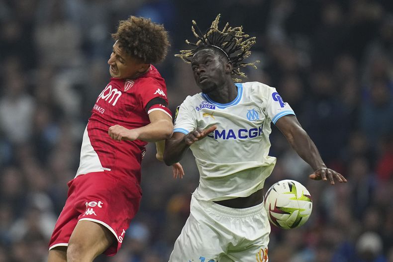 Eliesse Ben Seghir (izquierda), del Mónaco, disputa un centro con Bamo Mette, de Marsella, en un partido de la liga francesa, el sábado 27 de enero de 2024 (AP Foto/Daniel Cole)