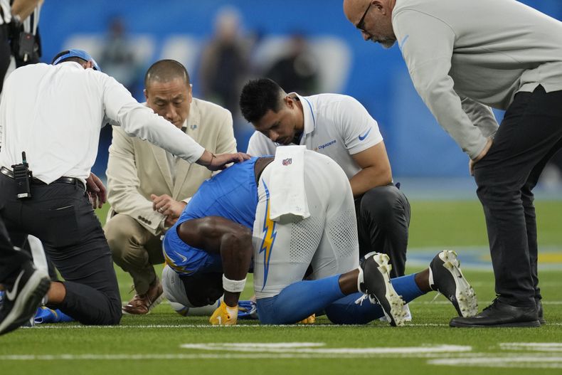 Joshua Palmer wide receiver de los Chargers de Los Ángeles es ayudado por el cuerpo médico del equipo tras una lesión durante la primera mitad del juego de NFL ante los Bears de Chicago, el domingo 29 de octubre de 2023, en Inglewood, California. (AP Foto/Ashley Landis)