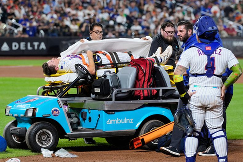 El primera base de los Mets de Nueva York Jared Young es sacado del terreno tras golpearse con el lanzador Nolan McLean durante el juego contra los Filis de Filadelfia, el jueves 17 de septiembre de 2026, en Nueva York. (AP Foto/Seth Wenig)