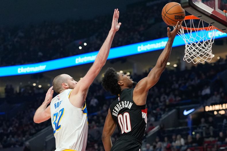 Scoot Henderson (00), base de los Trail Blazers de Portland, lanza ante Jay Huff (32), pívot de los Pacers de Indiana, durante la primera mitad de un juego de baloncesto de la NBA, el domingo 8 de marzo de 2026, en Portland, Ore. (Foto AP/Jenny Kane)