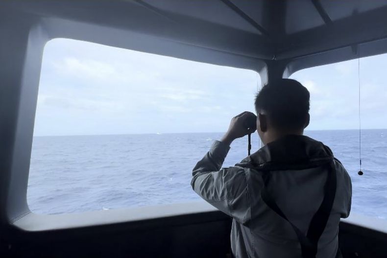 En esta imagen sin fecha de la Agencia de Seguridad Marítima de Indonesia, un miembro de la agencia emplea prismáticos para seguir el movimiento de un barco guardacostas chino en el mar de Natuna del Norte, una zona disputada del Mar de China Meridional, en Indonesia, el jueves 24 de octubre de 2024. (BAKAMLA via AP)
