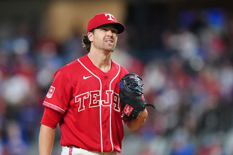 El lanzador abridor de los Rangers de Texas, Jacob deGrom, reacciona entre lanzamientos ante los Padres de San Diego durante la primera entrada de un partido de béisbol, el viernes 19 de junio de 2026, en Arlington, Texas. (Foto AP/Julio Cortez)