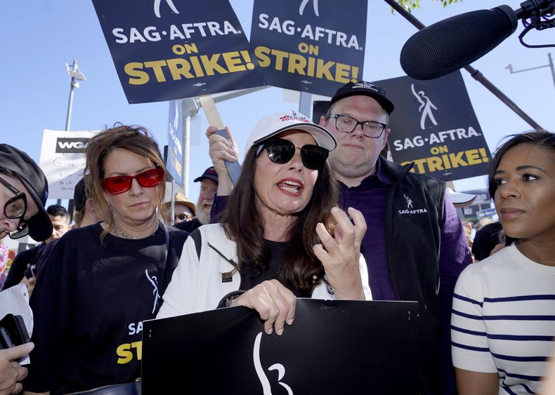 ARCHIVO - El actor Joely Fisher, de izquierda a derecha, la presidenta del sindicato de actores SAG-AFTRA, Fran Drescher, y Duncan Crabtree-Ireland, director ejecutivo nacional y principal negociador del SAG-AFTRA, participan en una manifestación de guionistas y actores en huelga frente al estudio de Netflix en Los Ángeles el 14 de julio de 2023. (Foto AP/Chris Pizzello, archivo)