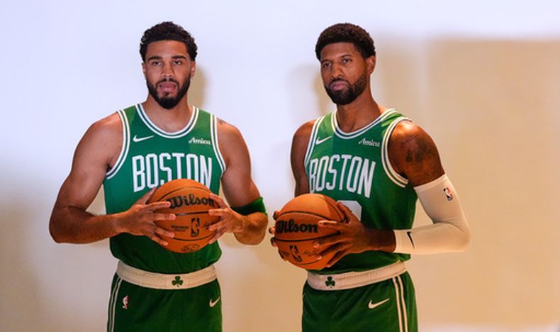 Jayson Tatum, izquierda, de los Celtics de Boston, y Paul George, derecha, posan juntos durante el Día de Medios del equipo de baloncesto de la NBA, el lunes 28 de septiembre de 2026, en Boston. (AP Foto/Charles Krupa)