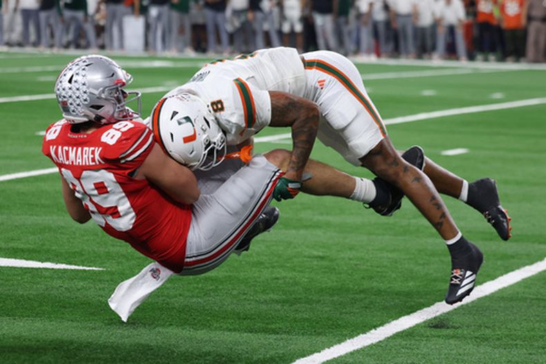 El back defensivo de Miami, Jakobe Thomas, derecha, derriba al ala cerrada de Ohio State, Will Kacmarek, durante la segunda mitad del partido de cuartos de final del Cotton Bowl College Football Playoff, el miércoles 31 de diciembre de 2025, en Arlington, Texas. (Foto AP/Gareth Patterson)