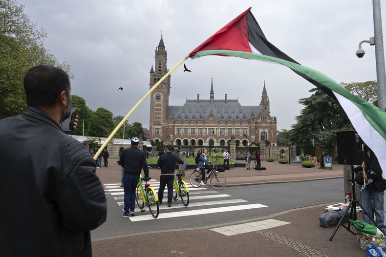 ARCHIVO - Un manifestante solitario ondea una bandera palestina fuera del Palacio de la Paz, sede de la Corte Internacional de Justicia, o Corte Mundial, en La Haya, Holanda, el 24 de mayo de 2024. (AP Foto/Peter Dejong, Archivo)