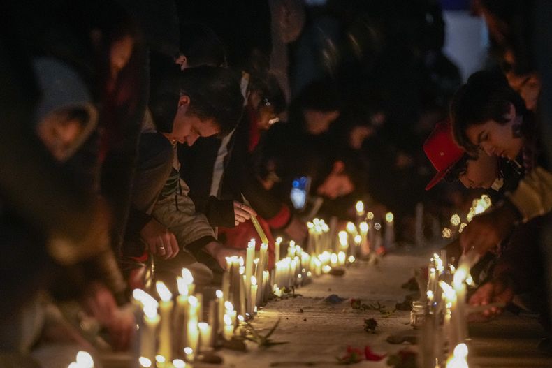 Gente enciende velas con los nombres de los detenidos desaparecidos durante la dictadura militar del general Augusto Pinochet, en Santiago, Chile, 11 de setiembre de 2023. España retiró el martes 12 de setiembre de 2023 una condecoración militar que le había otorgado el dictador Francisco Franco a Pinochet. (AP Foto/Esteban Felix)