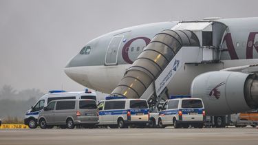 Varias personas embarcan en un avión de Qatar Airways, con vehículos de la policía federal estacionados delante, en la pista del aeropuerto Leipzig/Halle, el 18 de julio de 2025, en Sajonia, Schkeuditz. (Jan Woitas/dpa/dpa vía AP)