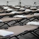 Bolsas con una almohada, toalla y sábanas sobre catres al interior de una carpa durante una gira de prensa en un albergue en la ciudad de Nueva York que albergará cerca de un millar de migrantes en el barrio Queens de Nueva York, el 15 de agosto de 2023. (AP Foto/Mary Altaffer, File)