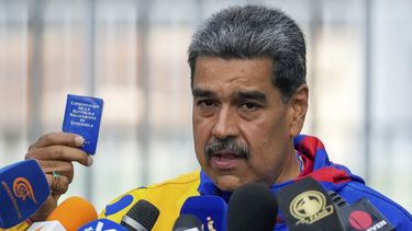 El presidente Nicolás Maduro muestra una mini edición de la Constitución venezolana después de votar en Caracas el domingo 28 de julio de 2024. (AP Foto/Fernando Vergara)