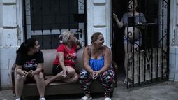 Varias mujeres pasan el tiempo fuera de casa durante el apagón masivo en el que derivó la caída en el funcionamiento de una de las mayores plantas termoeléctricas del país, en La Habana, Cuba, el viernes 18 de octubre de 2024. (AP Foto/Ramón Espinosa)