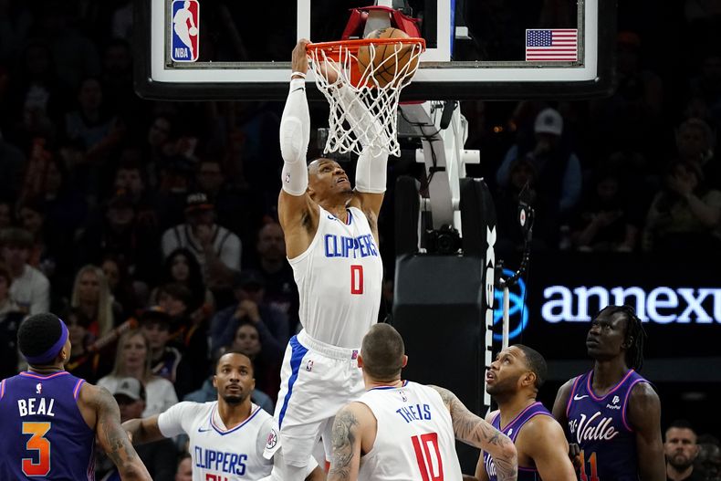 Russell Westbrook, de los Clippers de Los Ángeles, realiza una clavada frente a Bradley Beal, de los Suns de Phoenix, el miércoles 3 de enero de 2024 (AP Foto/Ross D. Franklin)