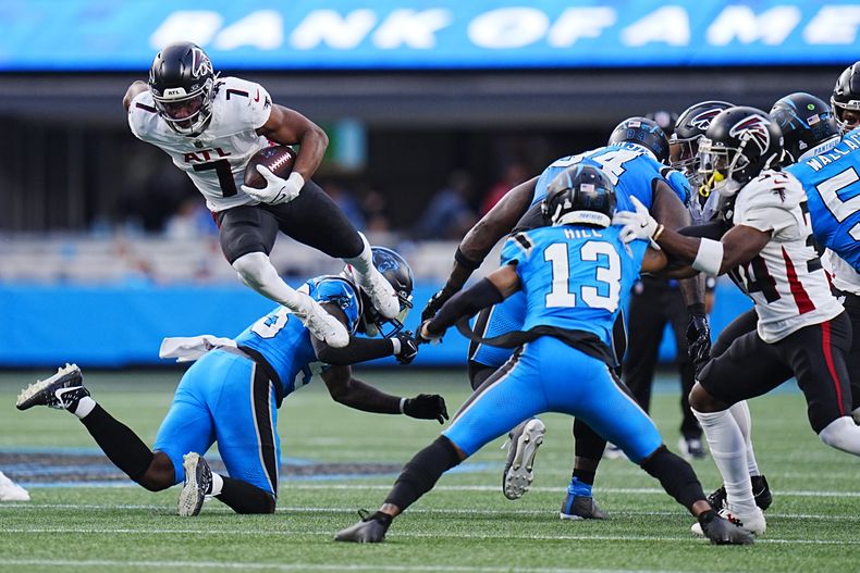 Bijan Robinson (7), running back de los Falcons de Atlanta, salta sobre el linebacker Claudin Cherelus (53), de los Panthers de Carolina, en la segunda mitad del juego de la NFL del domingo 13 de octubre de 2024, en Charlotte, Carolina del Norte. (AP Foto/Rusty Jones)