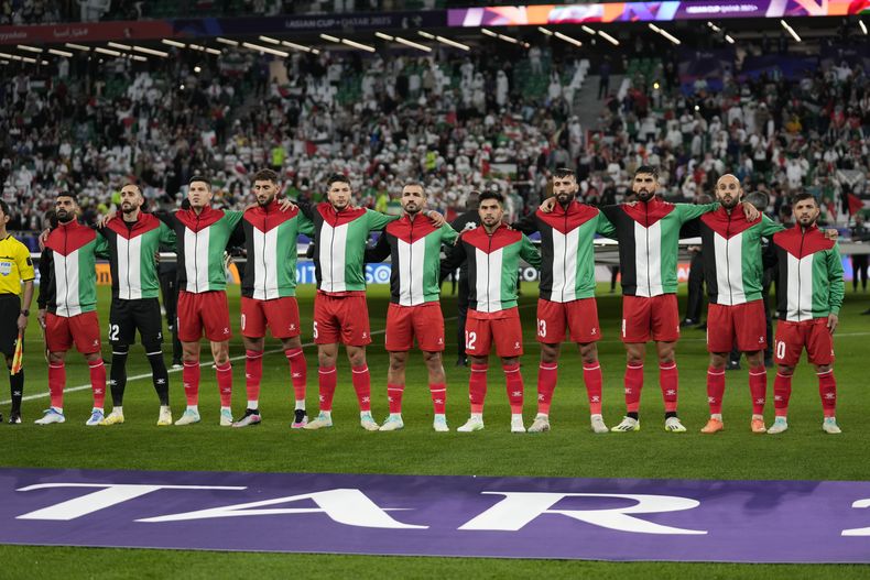 La selección nacional de Palestina de pie entonando el himno nacional previo al partido del Grupo C en la Copa de Asia entre Irán y Palstina en el Education City Stadium, en Rayán, Catar, el domingo 14 de junio de 2024. (AP Foto/Aijaz Rahi)