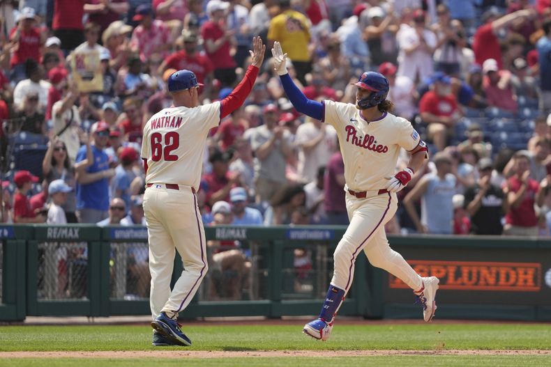 Alec Bohm, derecha, de los Filis de Filadelfia, celebra con el coach de tercera base Dusty Wathan después de batear un jonrón contra Génesis Cabrera, lanzador de los Cachorros de Chciago, durante la séptima entrada del juego de béisbol de Grandes Ligas, el miércoles 11 de junio de 2025, en Filadelfia. (AP Foto/Matt Slocum)