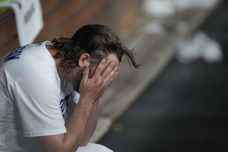 Clayton Kershaw, abridor de los Dodgers de Los Ángeles, se lleva las manos al rostro tras ser retirado del encuentro de playoffs ante los Diamondbacks de Arizona, el sábado 7 de octubre de 2023 (AP Foto/Ashley Landis)