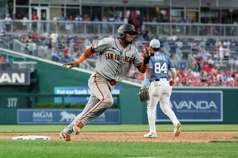 Luis Arráez de los Gigantes de San Francisco corre a tercera base para anotar con el sencillo de Matt Chapman frente al pitcher de los Nacionales de Washington Cionel Pérez en la 12ma entrada el sábado 18 de abril del 2026. (AP Foto/Terrance Williams)