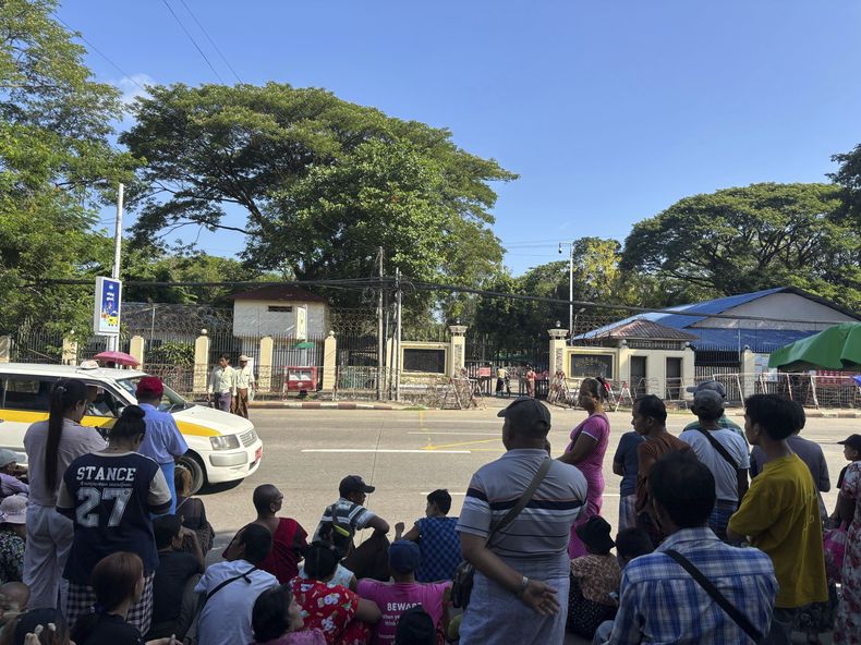 Familiares y colegas esperan para dar la bienvenida a prisioneros excarcelados fuera de la puerta principal de la prisión de Insein, durante la festividad tradicional por el día de Año Nuevo en el país, el jueves 17 de abril de 2025, en Rangún, Myanmar. (AP Foto/Thein Zaw)
