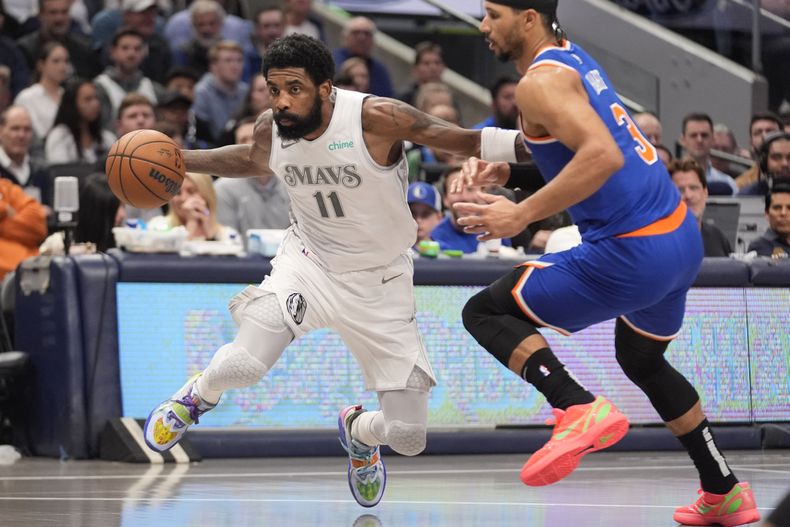 Kyrie Irving, base de los Mavericks de Dallas, elude a Josh Hart, de los Knicks de Nueva York, el miércoles 27 de noviembre de 2024 (AP Foto/LM Otero)