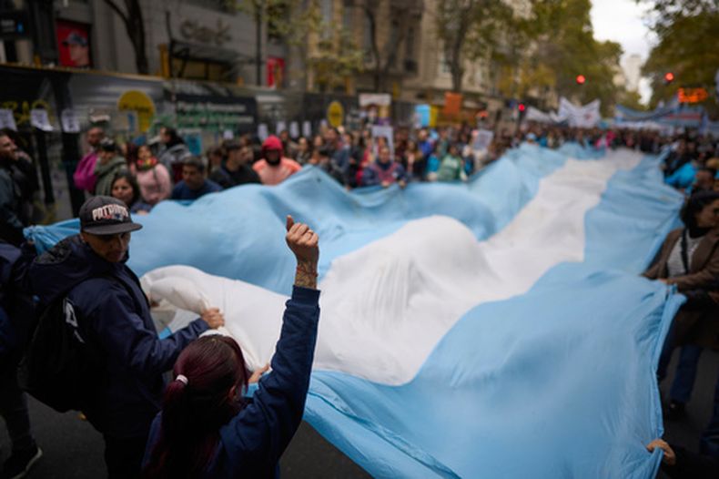 Manifestantes portan una bandera nacional durante una protesta para exigir mayor financiación para el sistema público de salud en Buenos Aires, Argentina, el miércoles 20 de mayo de 2026. (AP Foto/Víctor R. Caivano)