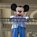 ARCHIVO - Un actor vestido como Mickey Mouse saluda a visitantes en la entrada del Parque Temático Magic Kingdom en Walt Disney World Resort, el 18 de abril de 2022, en Lake Buena Vista, Florida. Winnie the Pooh y Mickey Mouse han entrado recientemente en el dominio público, lo que hace posible que los artistas los usen libremente. (Foto AP/Ted Shaffrey, archivo)
