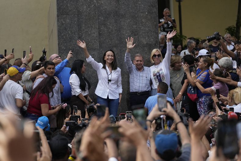 La lideresa de la oposición María Corina Machado, a la izquierda, y el candidato presidencial opositor Edmundo González, al centro, saludan a simpatizantes después de un evento de oración, el domingo 21 de julio de 2024, en Caracas. (AP Foto/Matias Delacroix)