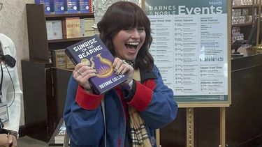 Ella Dolynchuk sostiene su ejemplar de Sunrise on the Reaping de Suzanne Collins en una fiesta de lanzamiento de medianoche en la librería Barnes & Noble en Nueva York el martes 18 de marzo de 2025. (Foto AP/Hillel Italie)