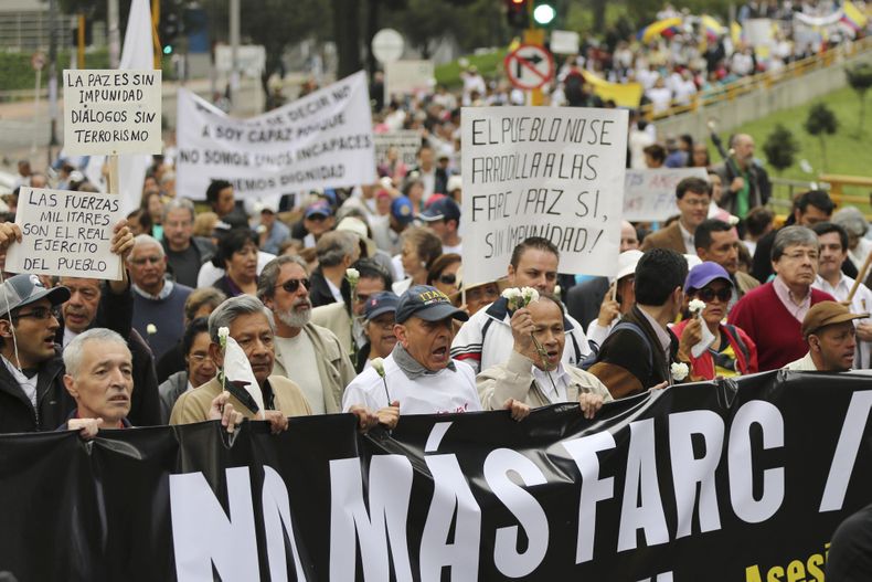Opositores de las conversaciones de paz del gobierno con las guerrillas de las FARC corean lemas durante una marcha en Bogot&aacute;, Colombia, el s&aacute;bado 13 de diciembre de 2014. (Foto AP/Fernando Vergara)