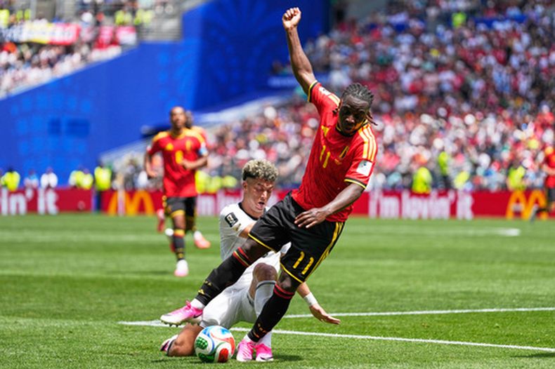 El belga Jeremy Doku, al frente, disputa un balón con el egipcio Emam Ashour, durante su partido por el Grupo G del Mundial, el lunes 15 de junio de 2026, en Seattle. (AP Foto/Lindsey Wasson)