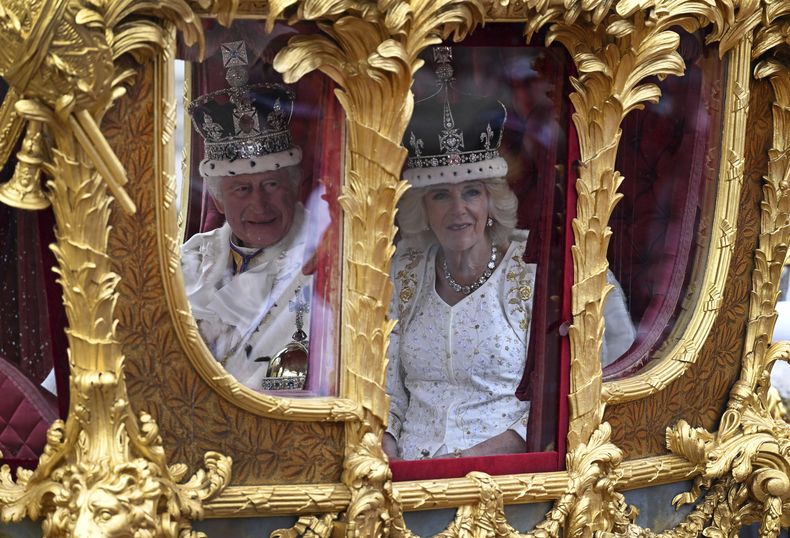 Sus majestades el rey Carlos III y la reina Camila a bordo de un carruaje dorado de camino al Palacio de Buckingham, desde la Abadía de Westminster, en Londres, tras su ceremonia de coronación el sábado 6 de mayo de 2023. (Charles McQuillan/pool photo via AP)