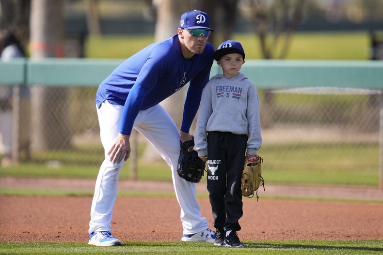 ARCHIVO - Freddie Freeman, primera base de los Dodgers de Los Ángeles, participa con su hijo Charlie en los entrenamientos de pretemporada en Phoenix, el 18 de febrero de 2024 (AP Foto/Ashley Landis, archivo)