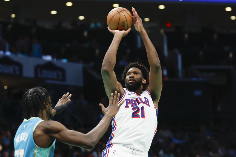 Joel Embiid, de los 76ers de Filadelfia, dispara frente a Nathan Mensah, de los Hornets de Charlotte, durante el partido del sábado 16 de diciembre de 2023 (AP Foto/Nell Redmond)